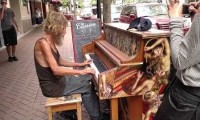 Bezdomny mężczyzna gra na pianinie