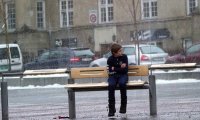 Zmarznięty chłopiec na przystanku